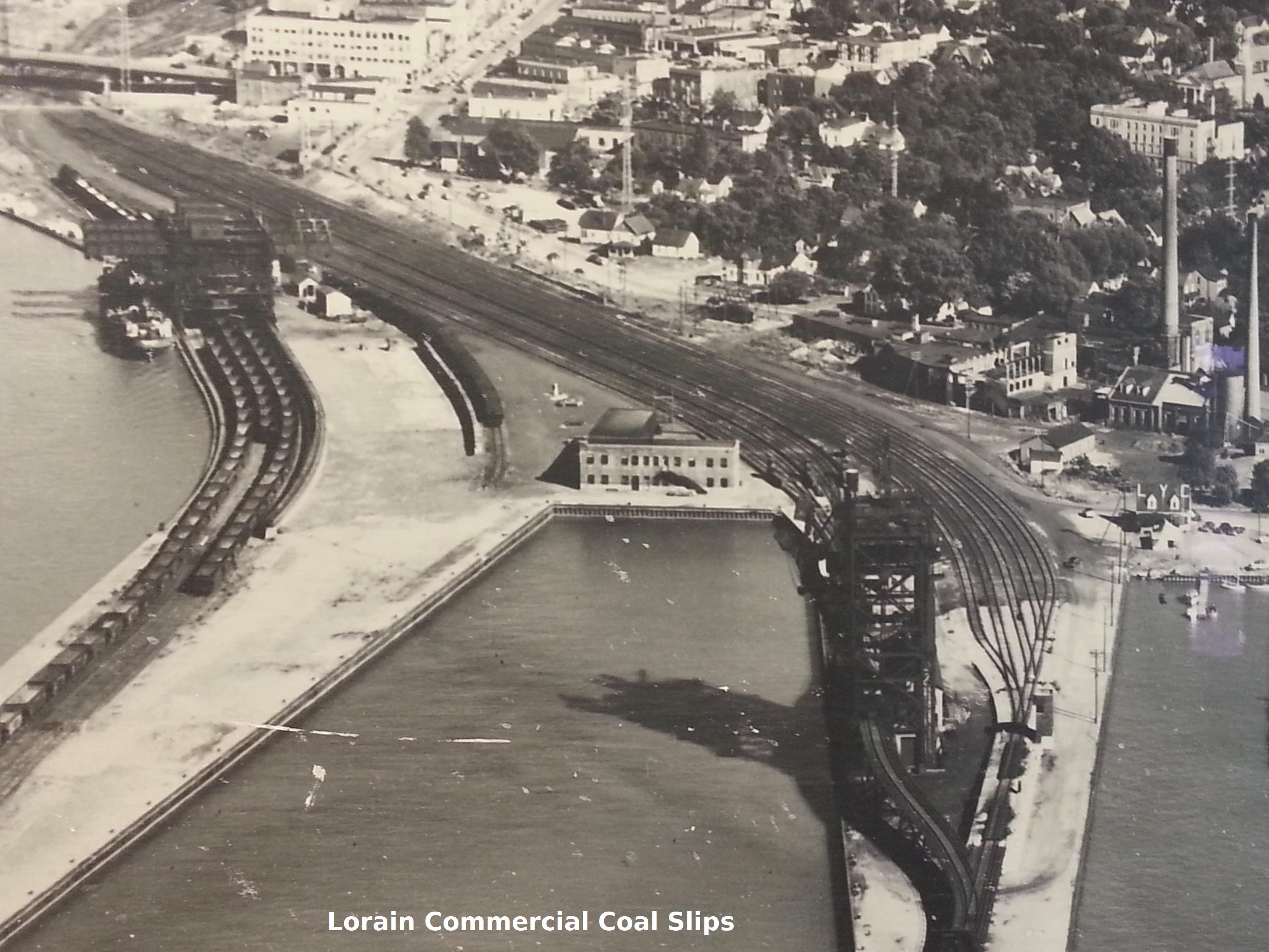 Historic aerial photo of rail yards along the river, labeled "Lorain Commercial Coal Slips"